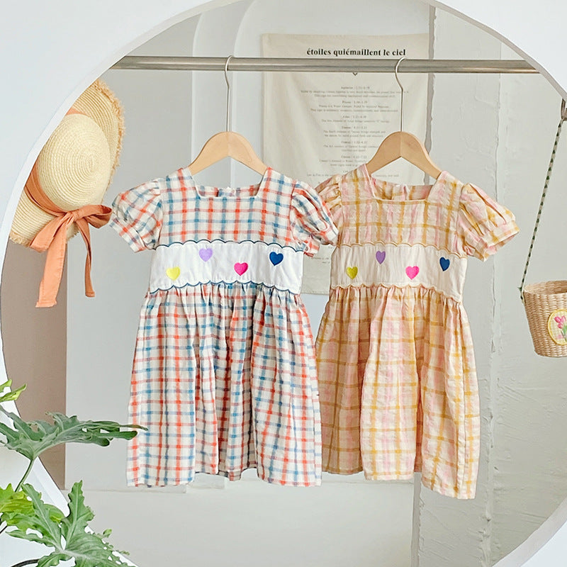 A colorful plaid dress for girls featuring short sleeves and heart embroidery, perfect for summer outings.