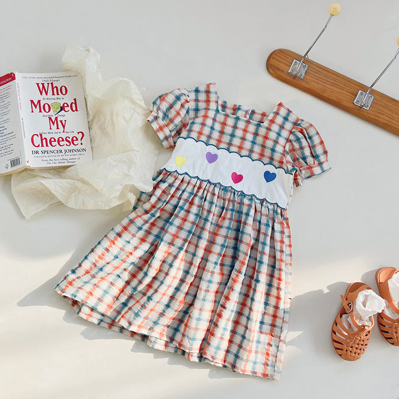 A colorful plaid dress for girls featuring short sleeves and heart embroidery, perfect for summer outings.