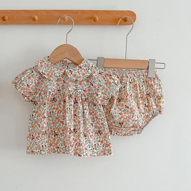 A vibrant summer top for baby girls featuring a floral design, available in red and blue colors, made from soft cotton.