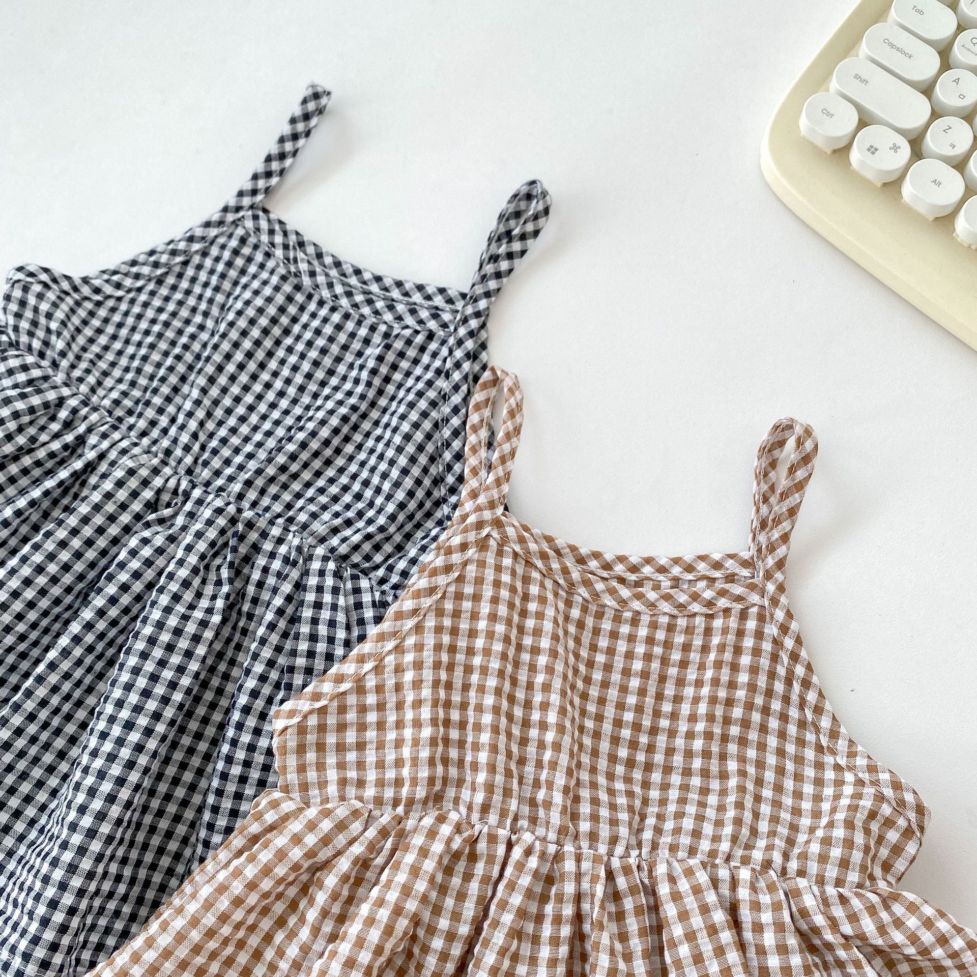 Summer New Arrival Baby Girls Plaid Sleeveless Strap Onesies Dress in black and brown colors, made from soft cotton, perfect for warm weather.