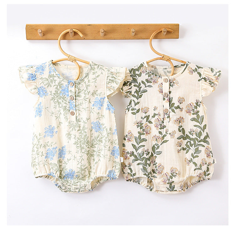 A cute baby girl wearing a floral print dress with fly sleeves in blue and gold, perfect for summer outings.