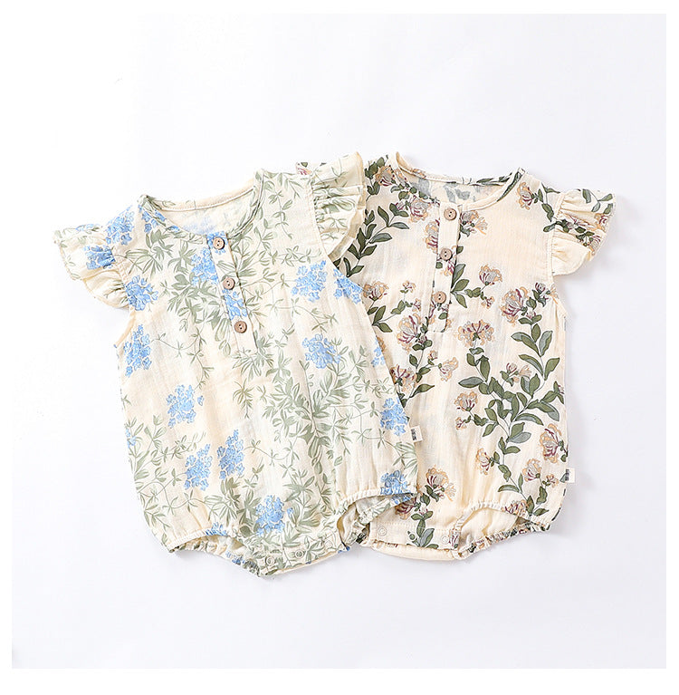 A cute baby girl wearing a floral print dress with fly sleeves in blue and gold, perfect for summer outings.