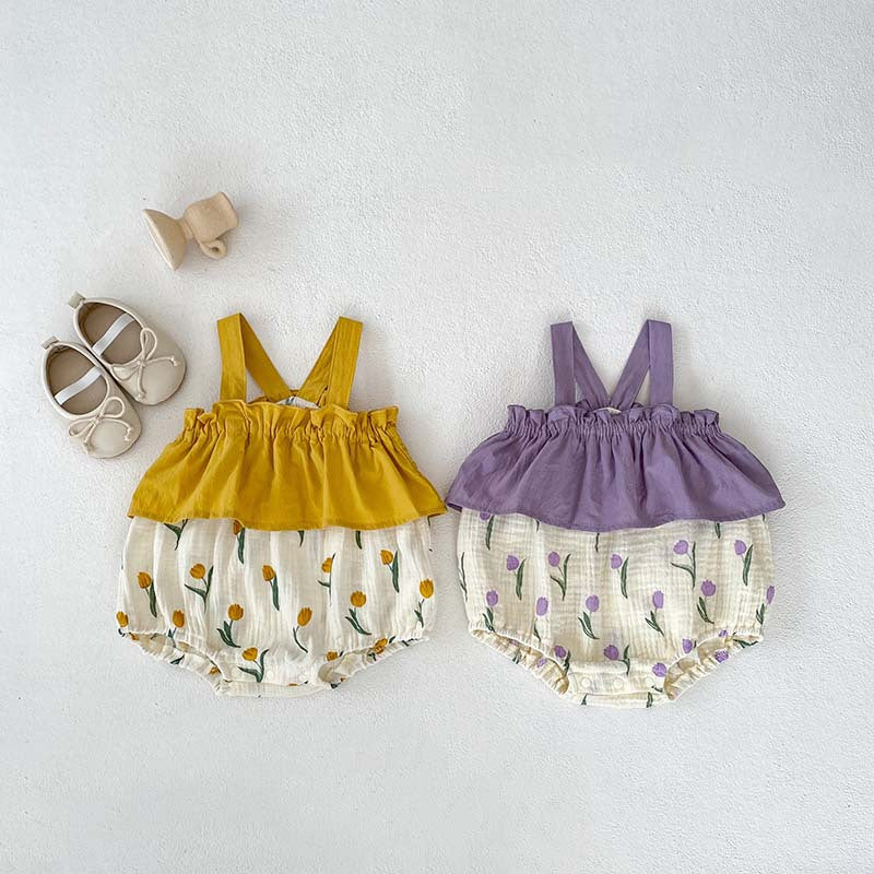 A cute baby girl wearing a sleeveless summer dress with a flowers pattern in purple and yellow colors, perfect for warm weather.