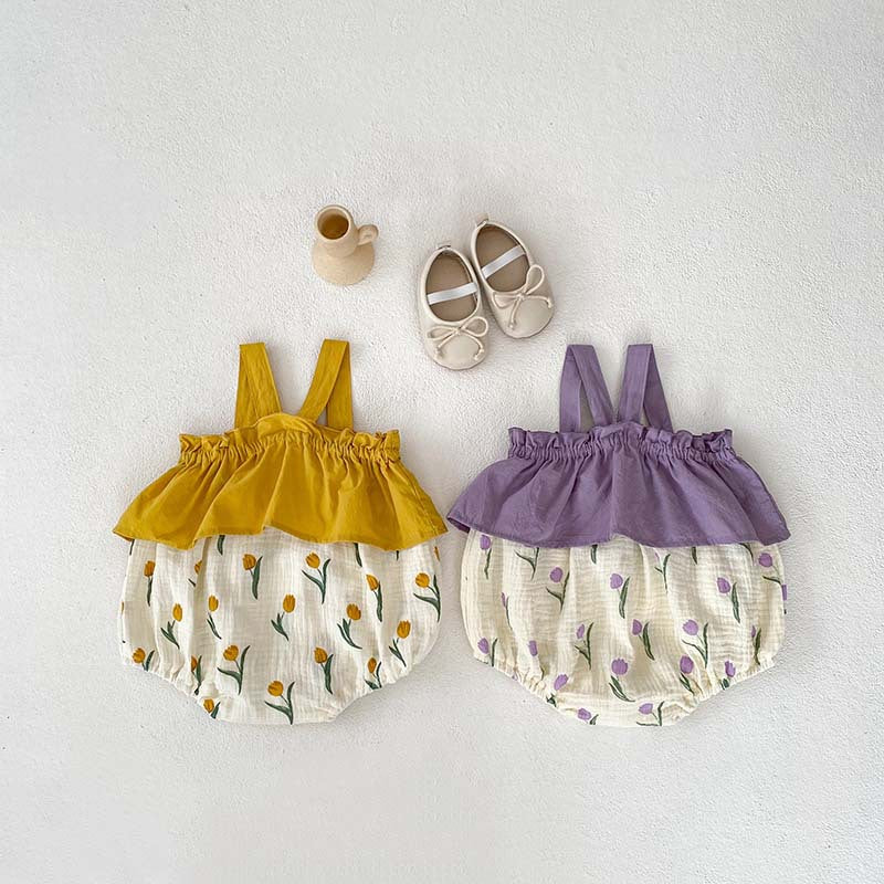 A cute baby girl wearing a sleeveless summer dress with a flowers pattern in purple and yellow colors, perfect for warm weather.