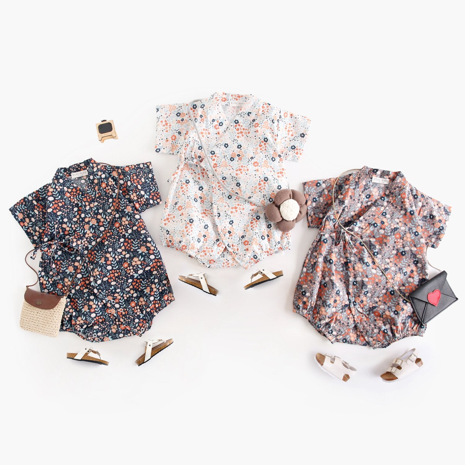 A cute baby wearing a floral print short sleeves V neck shirt in white, showcasing a vibrant floral design, perfect for summer.