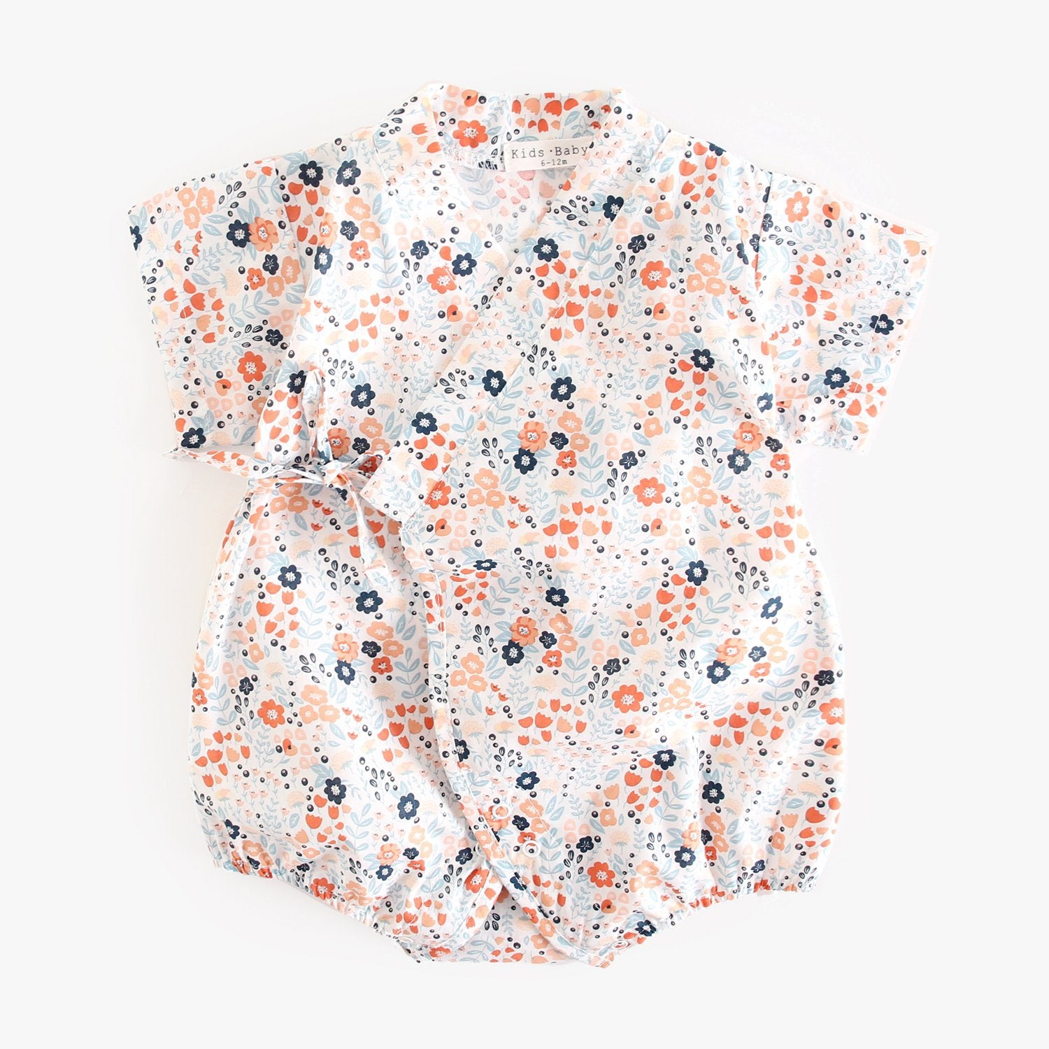 A cute baby wearing a floral print short sleeves V neck shirt in white, showcasing a vibrant floral design, perfect for summer.