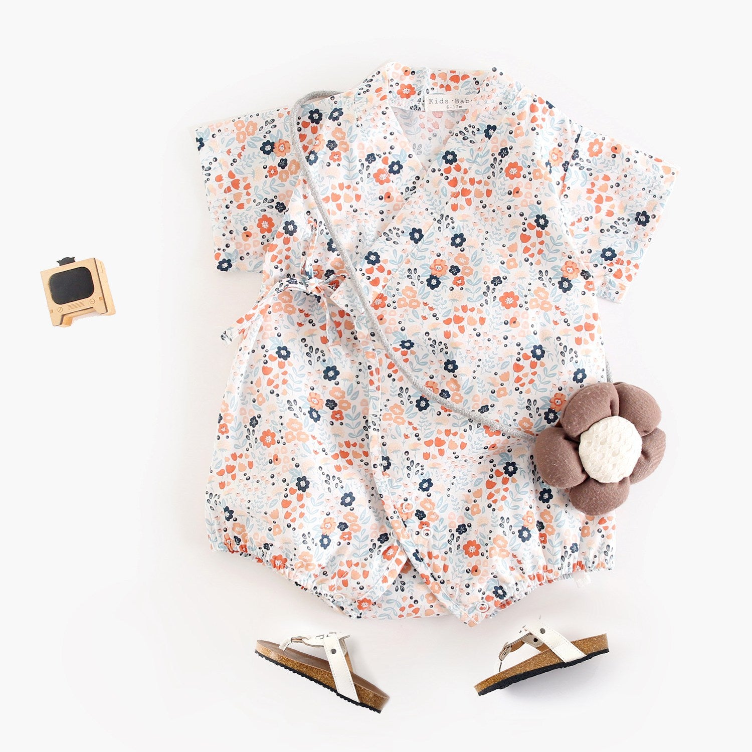 A cute baby wearing a floral print short sleeves V neck shirt in white, showcasing a vibrant floral design, perfect for summer.