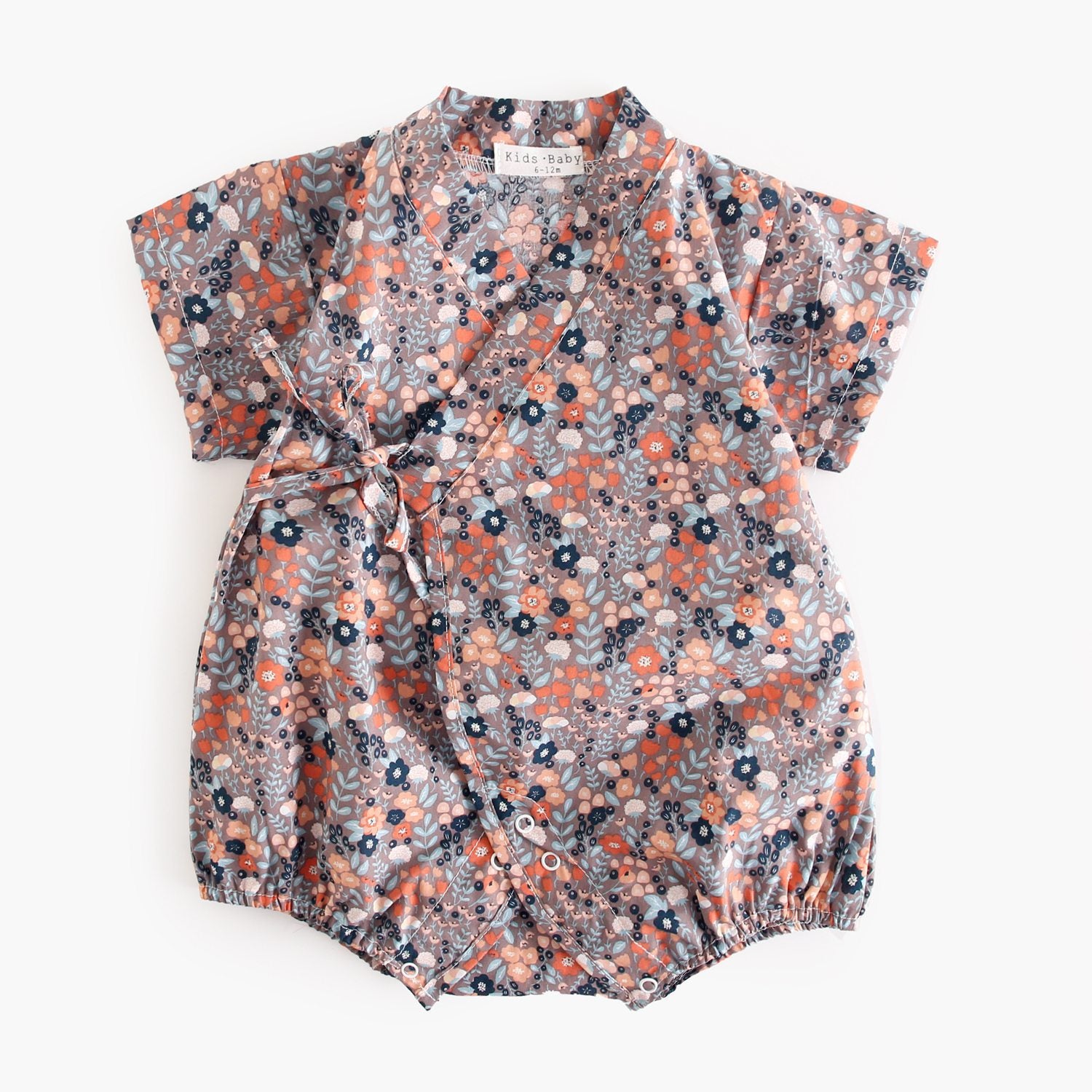 A cute baby wearing a floral print short sleeves V neck shirt in white, showcasing a vibrant floral design, perfect for summer.