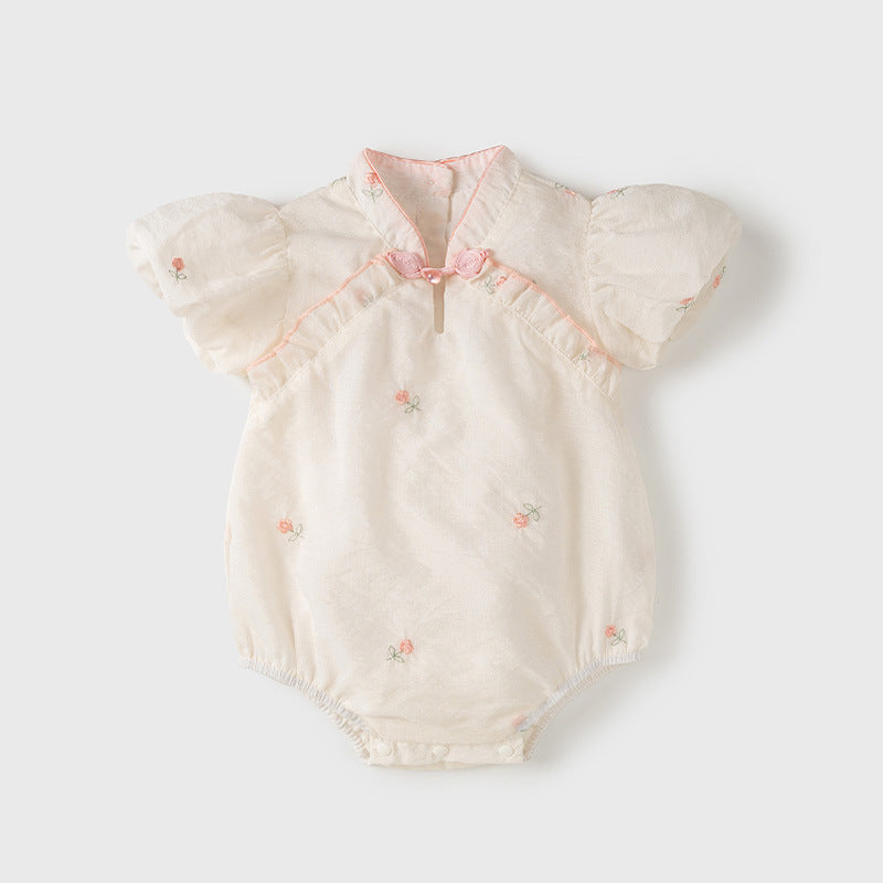 A baby girl wearing a light floral pattern short sleeves stand outfit in apricot color, perfect for summer.