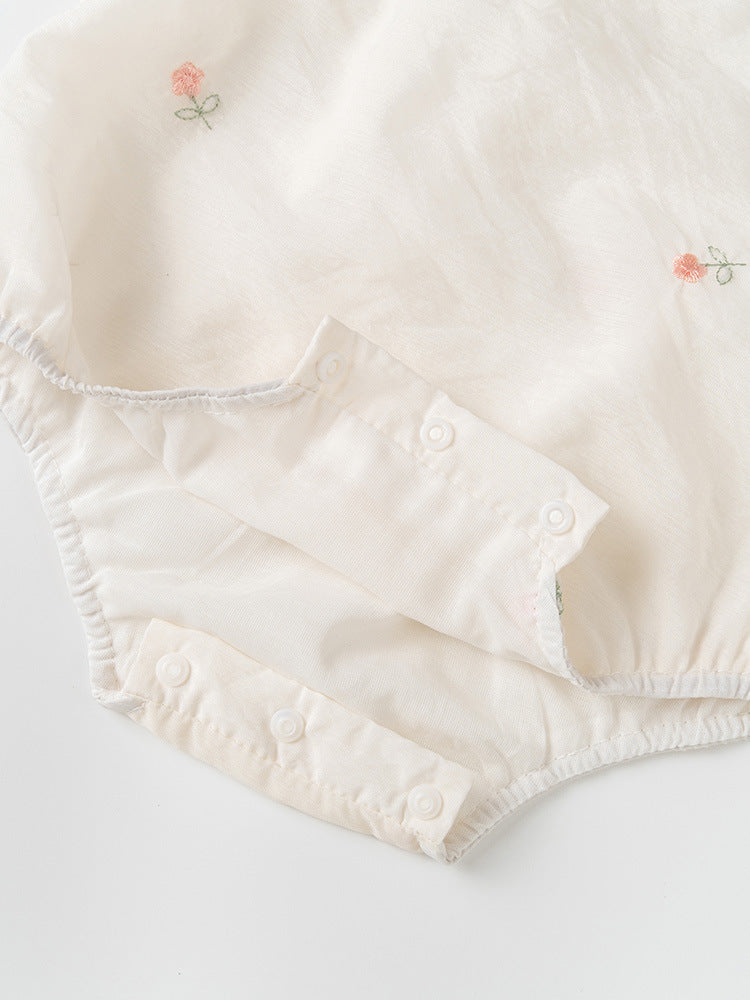 A baby girl wearing a light floral pattern short sleeves stand outfit in apricot color, perfect for summer.