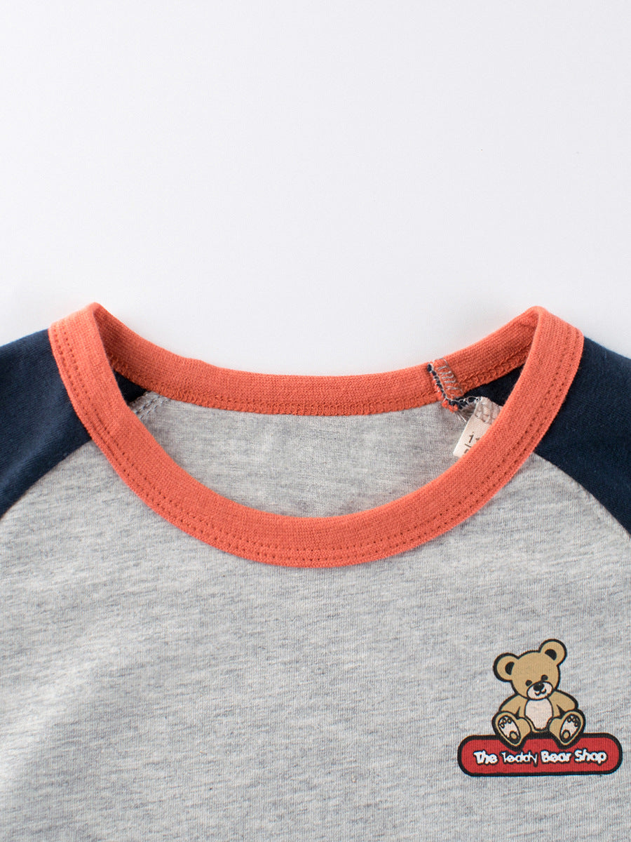 A grey girls' t-shirt featuring a cute teddy bear logo, made from soft cotton, perfect for summer wear.