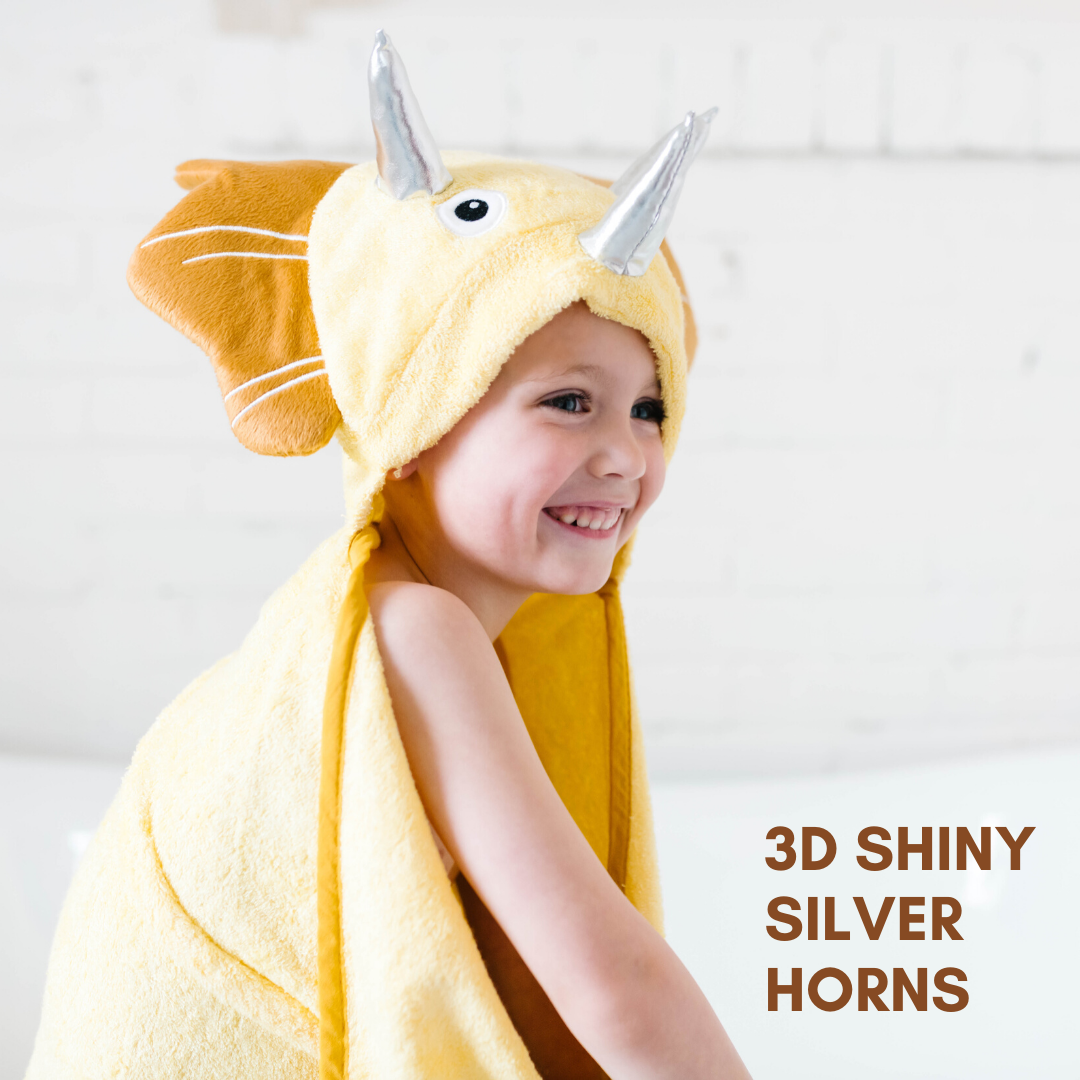 A soft yellow dinosaur hooded towel designed for toddlers, featuring 3D shiny silver horns and velvety frills, perfect for bath time.