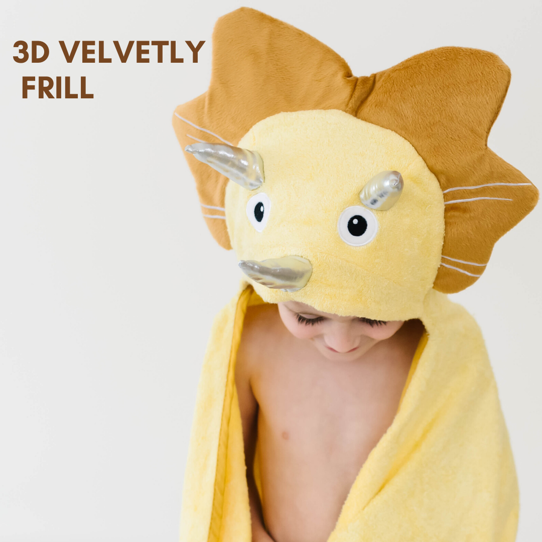 A soft yellow dinosaur hooded towel designed for toddlers, featuring 3D shiny silver horns and velvety frills, perfect for bath time.