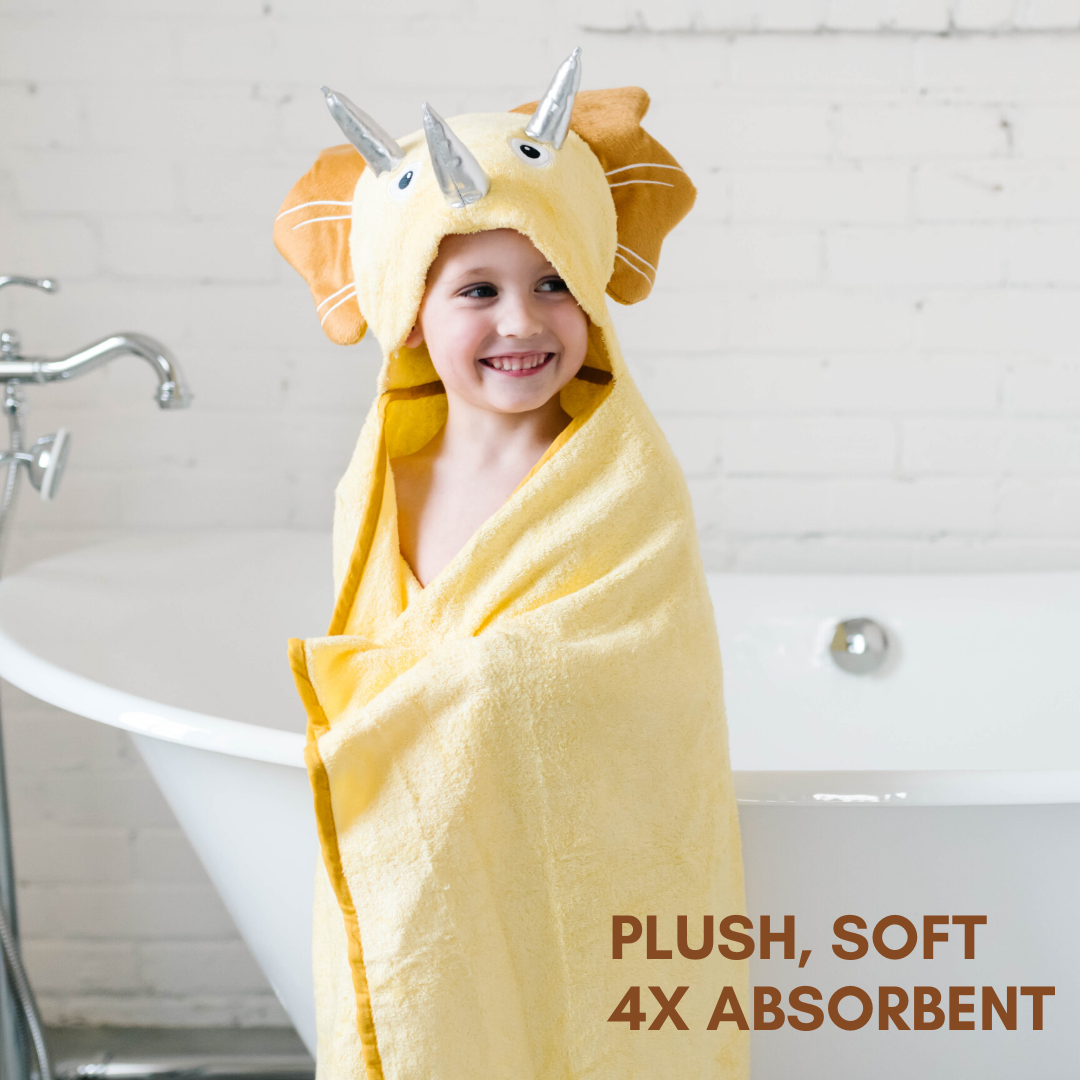 A soft yellow dinosaur hooded towel designed for toddlers, featuring 3D shiny silver horns and velvety frills, perfect for bath time.