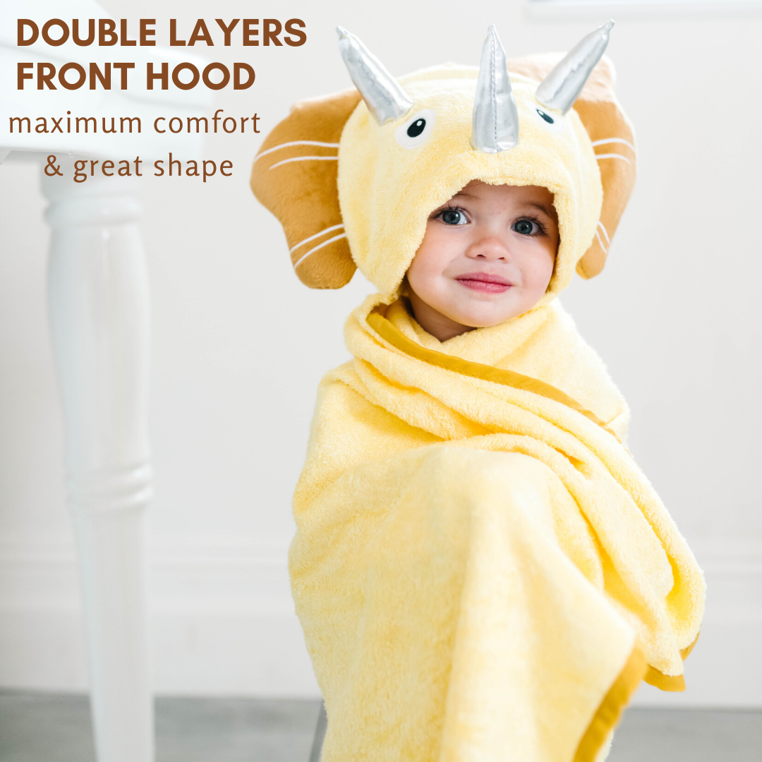 A soft yellow dinosaur hooded towel designed for toddlers, featuring 3D shiny silver horns and velvety frills, perfect for bath time.