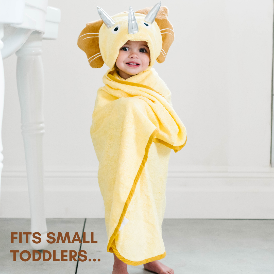 A soft yellow dinosaur hooded towel designed for toddlers, featuring 3D shiny silver horns and velvety frills, perfect for bath time.