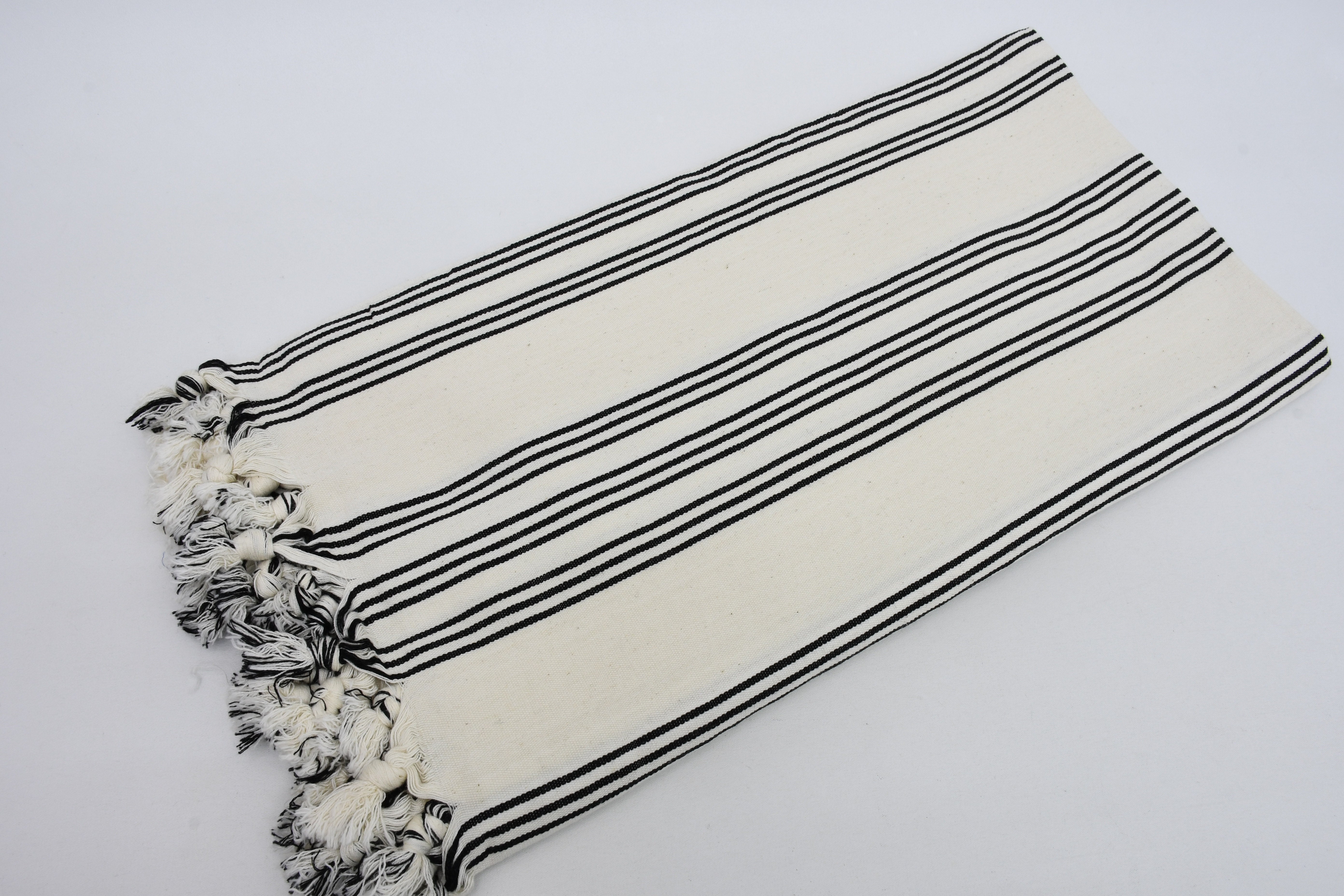 Turkish Beach Towel featuring a stylish black and white stripe design, handwoven from natural cotton, perfect for beach outings.