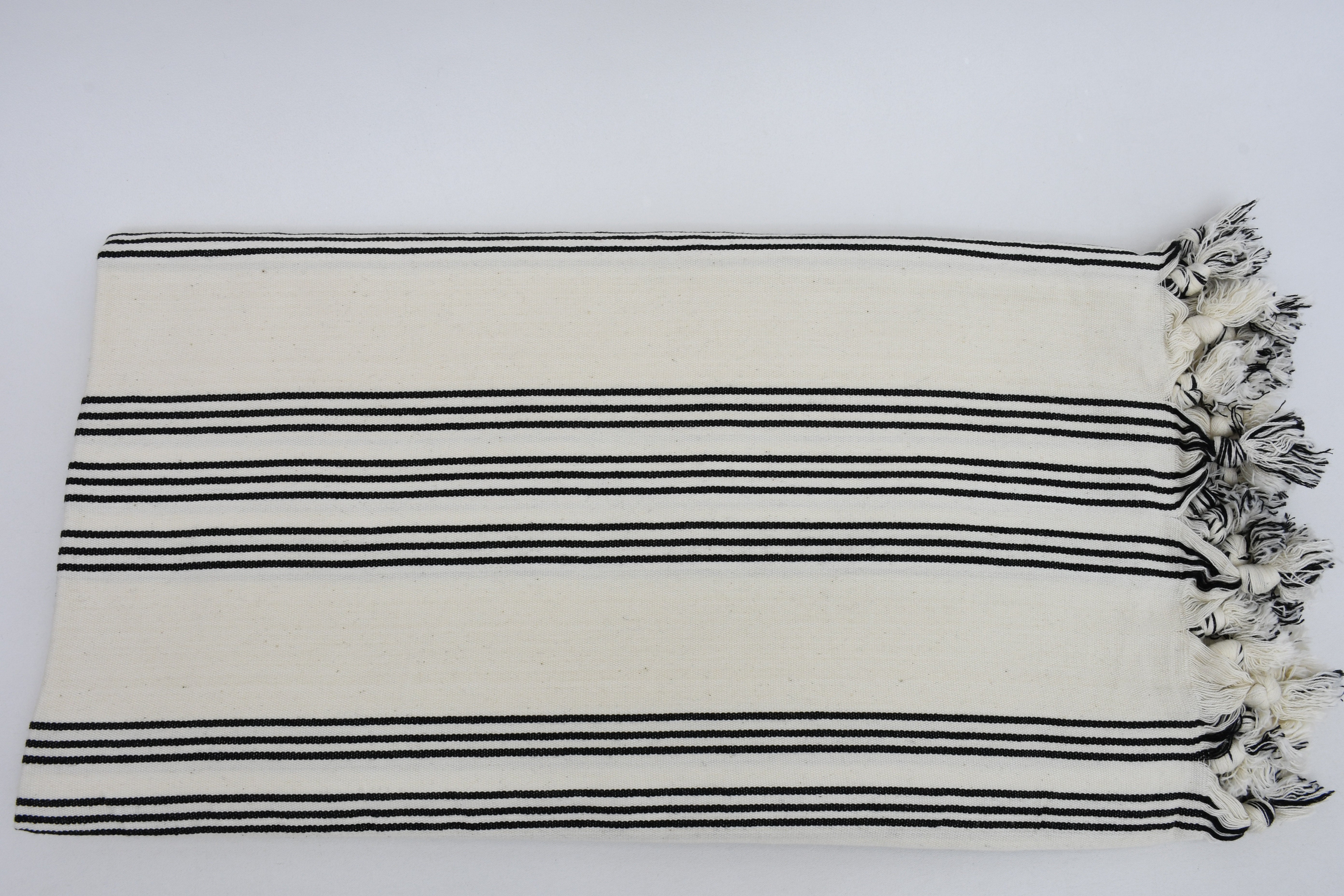 Turkish Beach Towel featuring a stylish black and white stripe design, handwoven from natural cotton, perfect for beach outings.