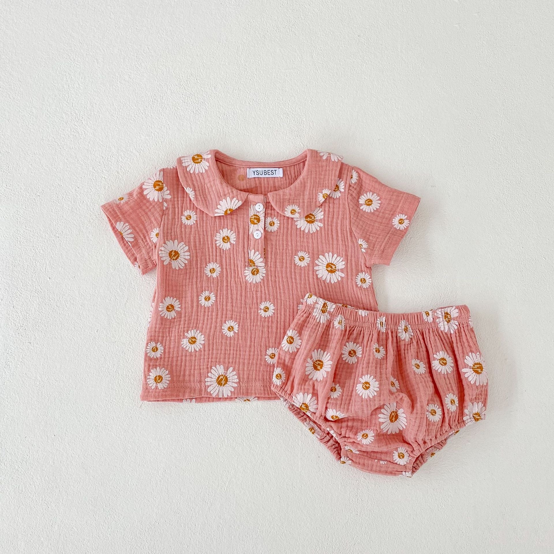 A stylish summer top for baby girls featuring short sleeves and a floral pattern in pink and khaki colors.