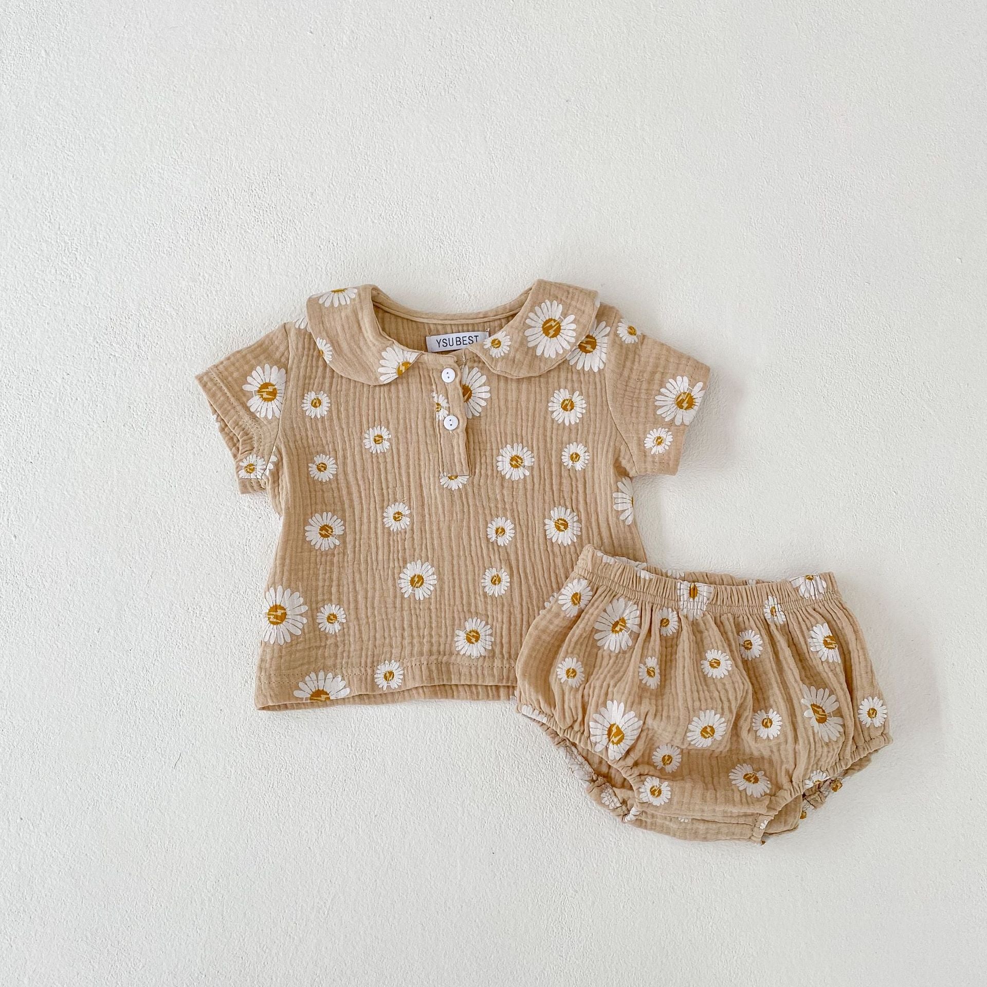 A stylish summer top for baby girls featuring short sleeves and a floral pattern in pink and khaki colors.