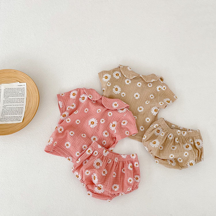 A stylish summer top for baby girls featuring short sleeves and a floral pattern in pink and khaki colors.