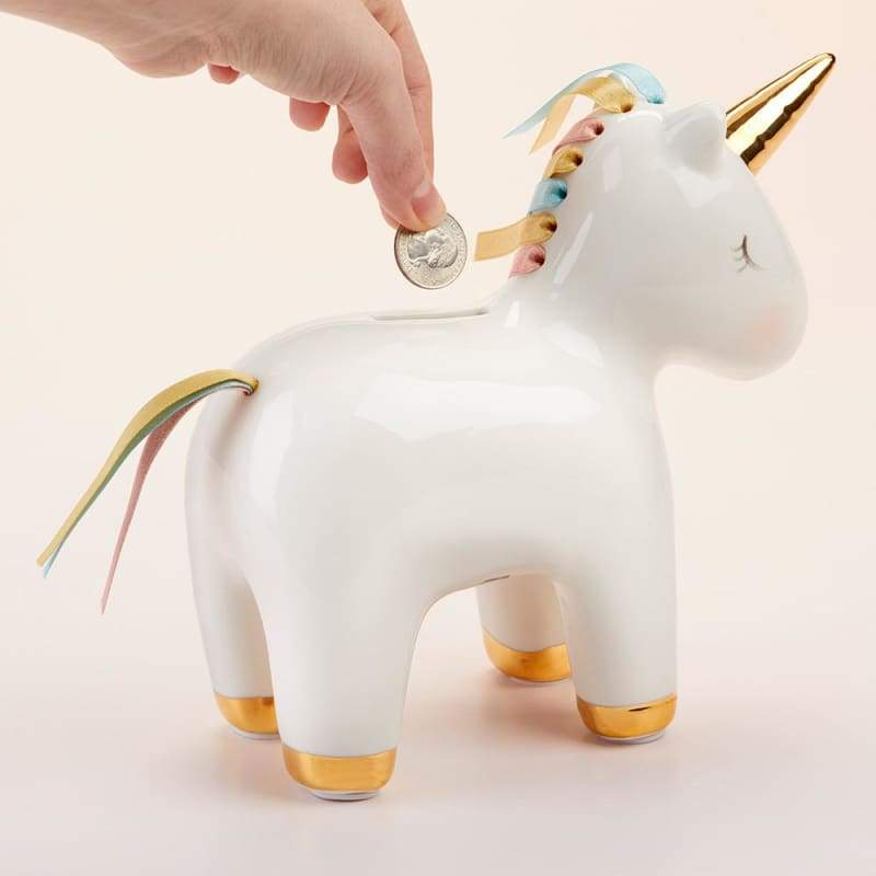 A beautifully crafted white porcelain unicorn bank with a gold foil horn and hooves, featuring a colorful mane and tail made of pink, aqua, and gold ribbons.