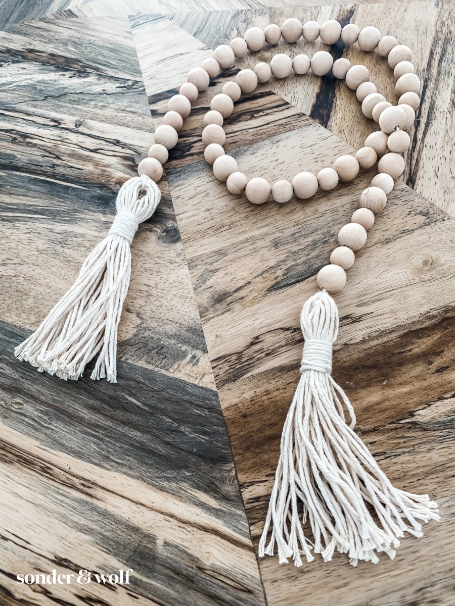 Handmade variated wood bead garland featuring cotton tassels, perfect for home decor.