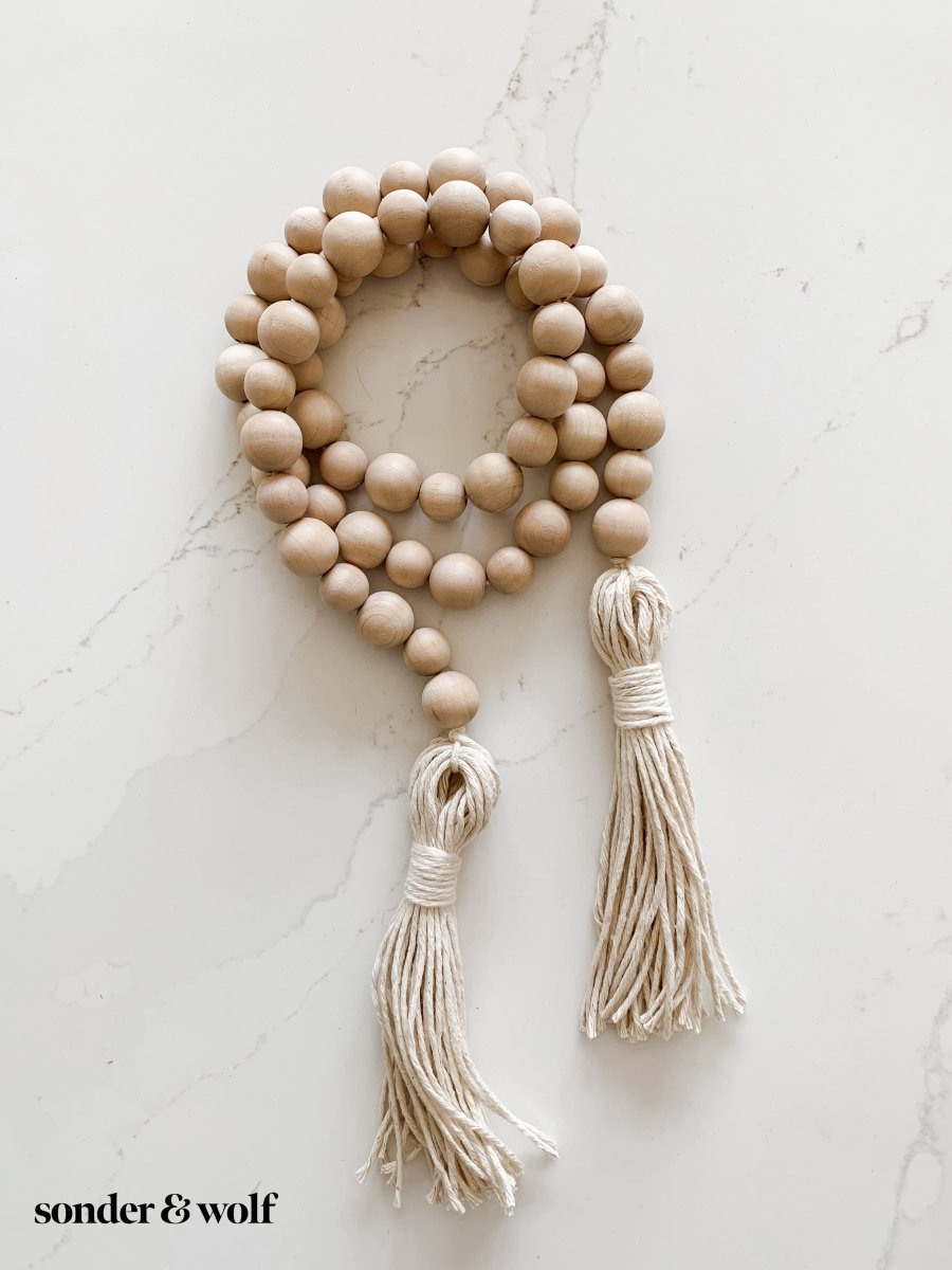 Handmade variated wood bead garland featuring cotton tassels, perfect for home decor.