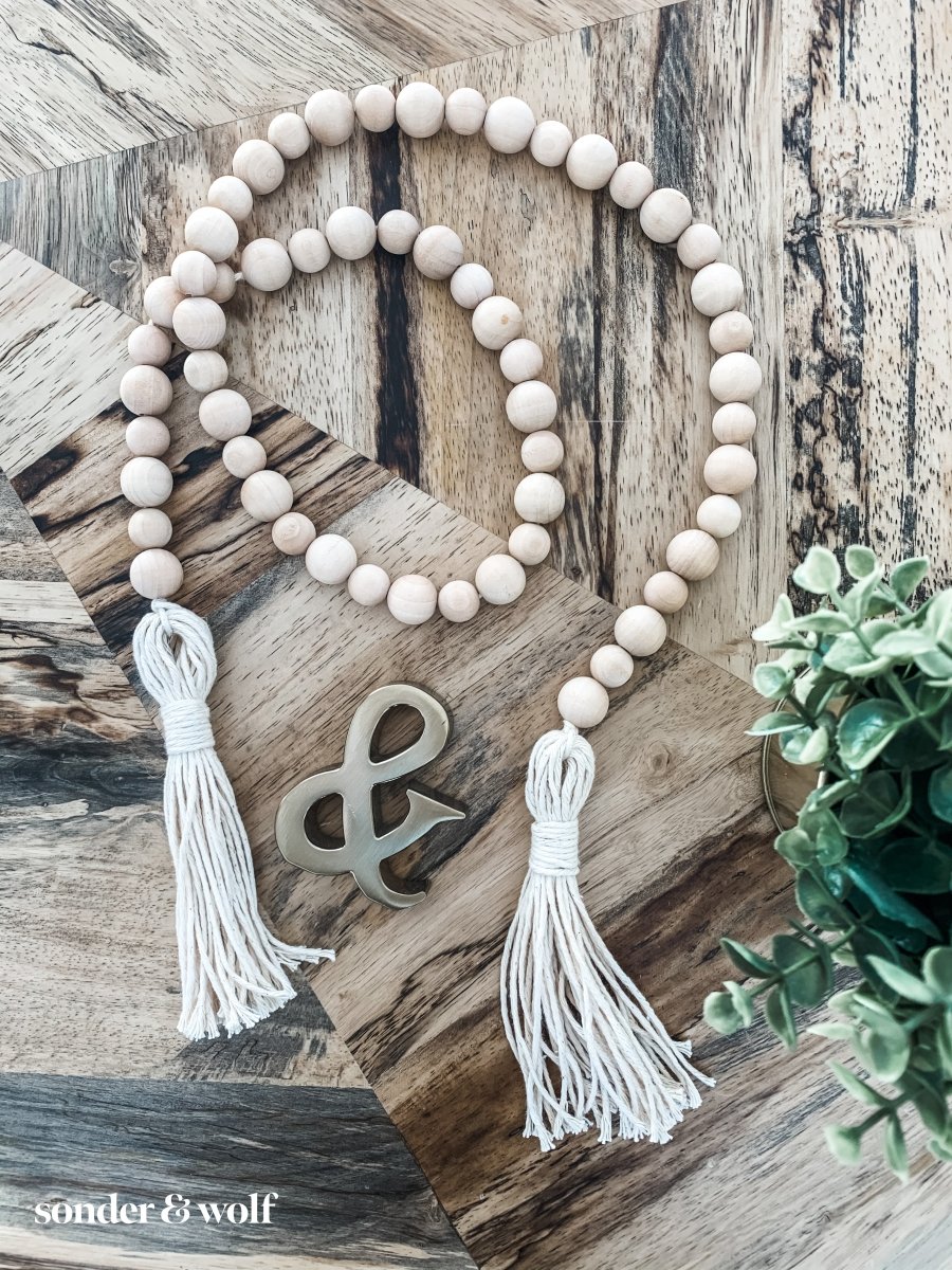 Handmade variated wood bead garland featuring cotton tassels, perfect for home decor.