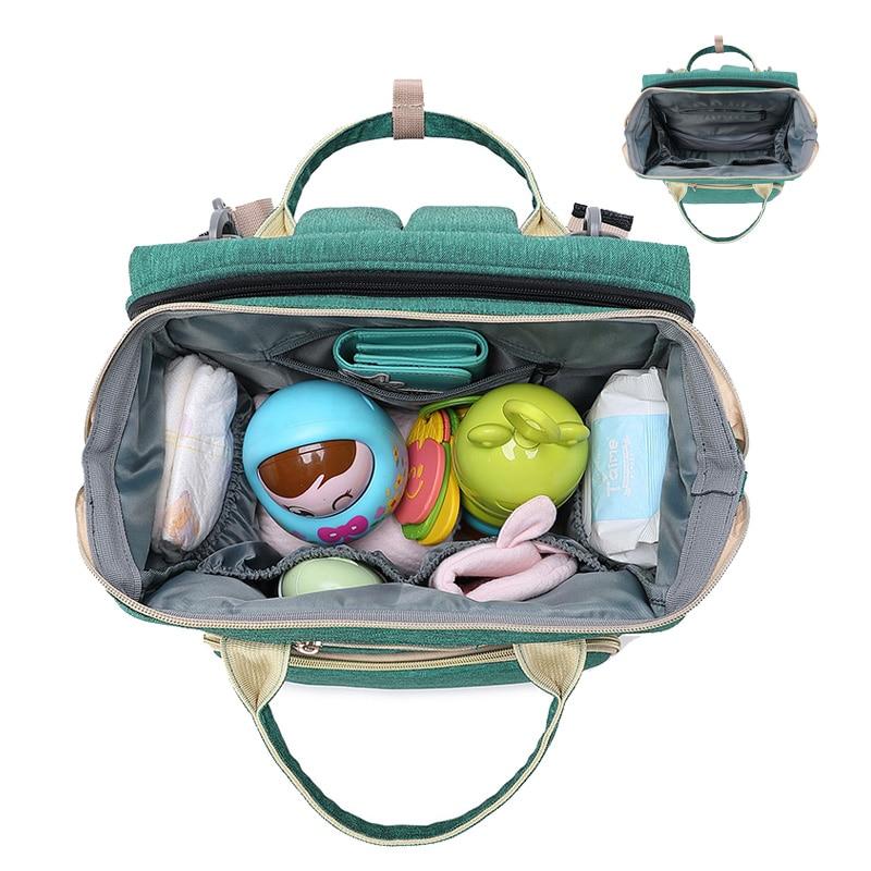 Warehouse Multifunctional Baby Folding Bed Diaper Bag in stylish design, showcasing its folding bed feature and USB charging port.