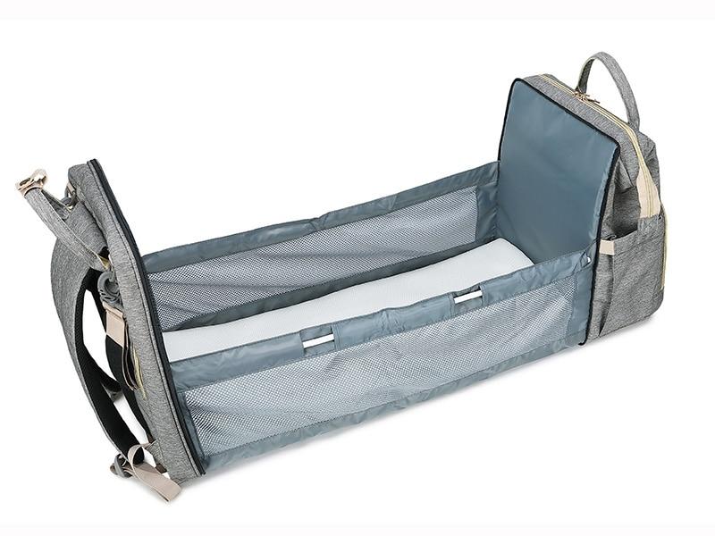 Warehouse Multifunctional Baby Folding Bed Diaper Bag in stylish design, showcasing its folding bed feature and USB charging port.