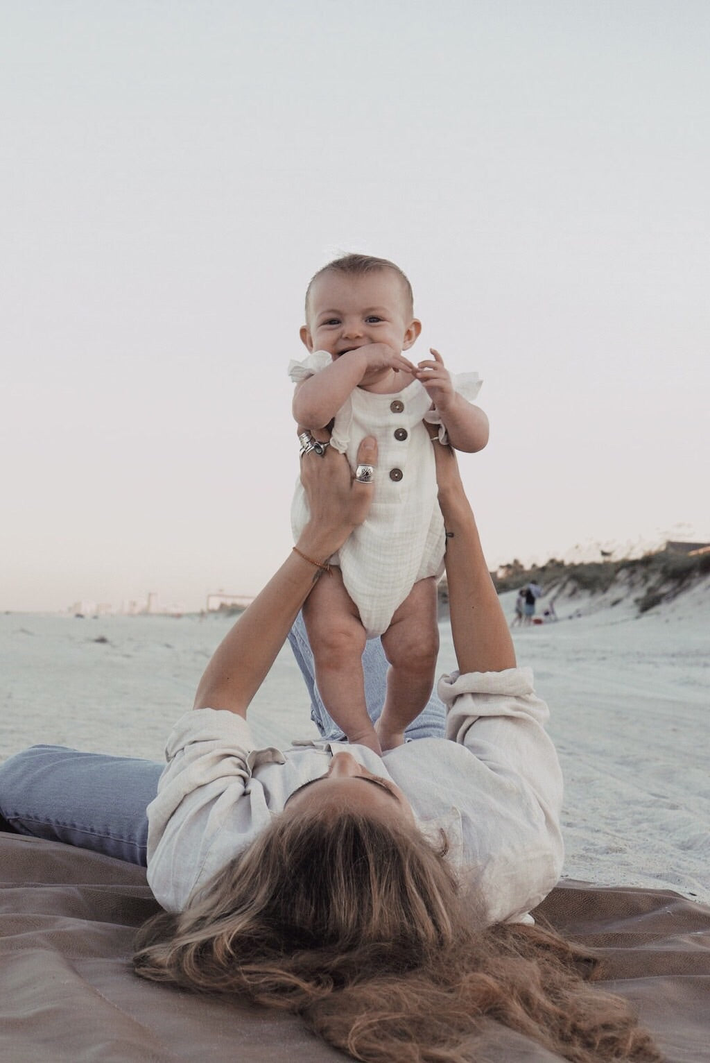 A stylish white summer romper for babies, made from breathable linen with diaper snaps and non-toxic dyes.