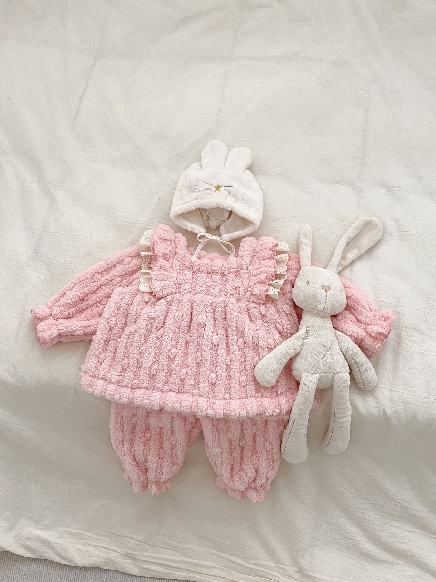 A cozy winter dress for baby girls featuring thick thermal fabric, long sleeves, and playful dot and plaid patterns in white and pink.