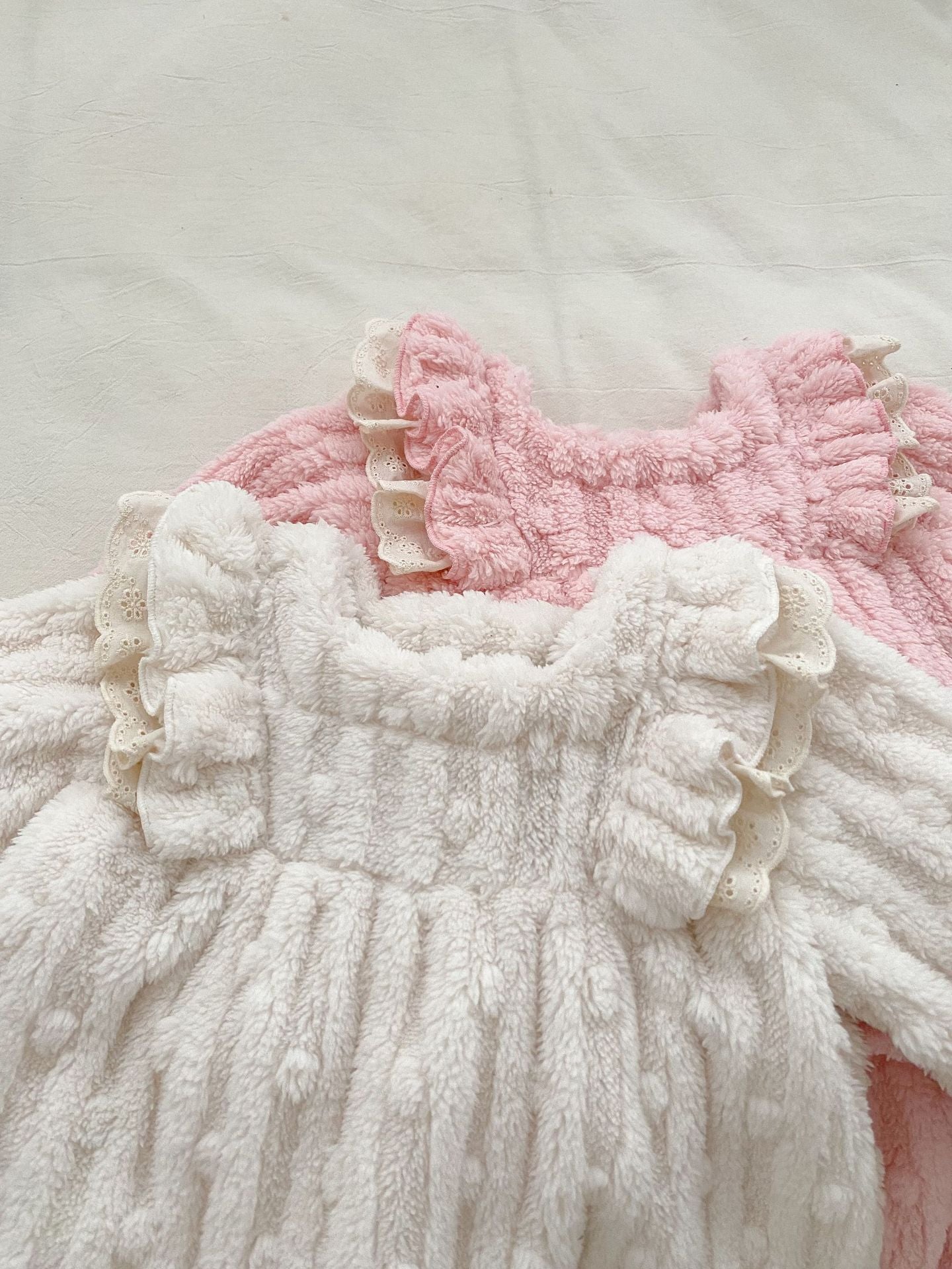 A cozy winter dress for baby girls featuring thick thermal fabric, long sleeves, and playful dot and plaid patterns in white and pink.