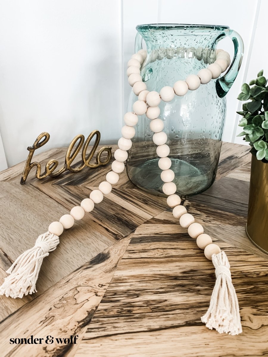 Handmade wood bead garland with 6-inch cotton tassels, perfect for home decor.