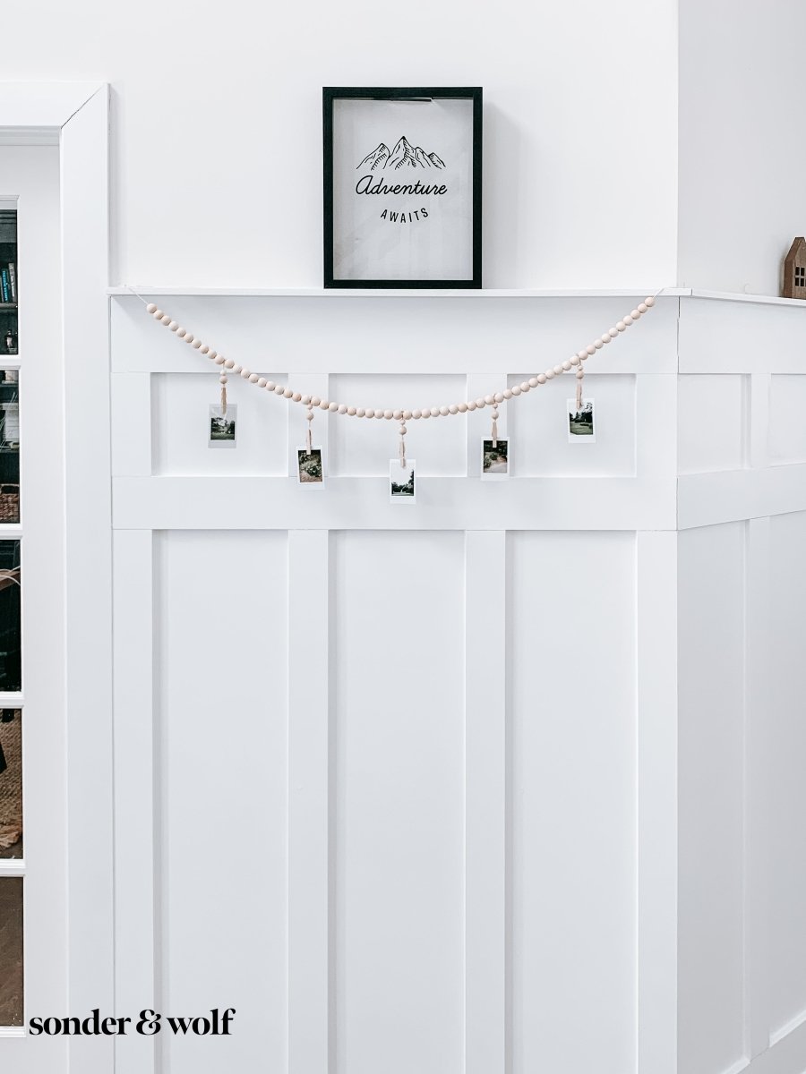 Wood Bead Garland featuring clothespins for hanging photos and masks, showcasing light unfinished wood beads and decorative loops.