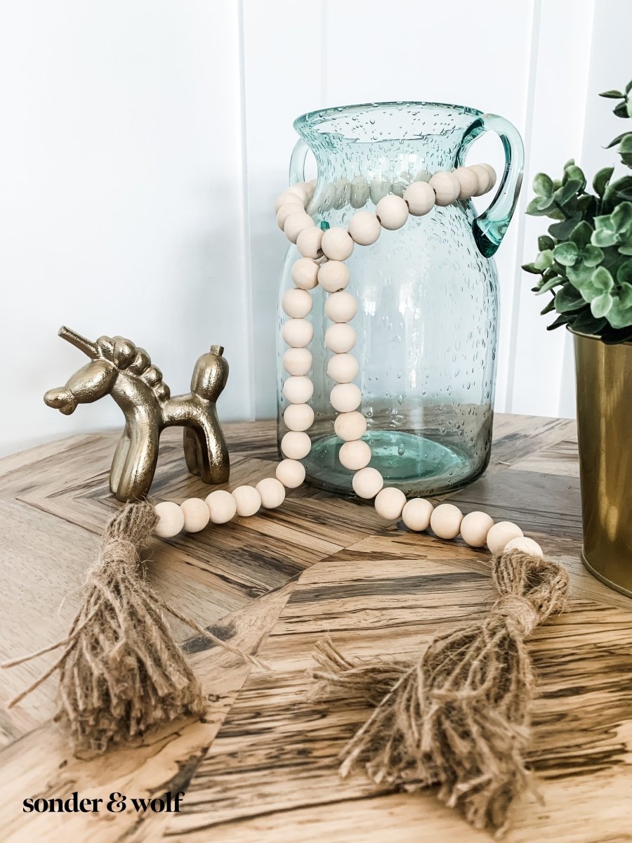 Handmade wood bead garland with jute tassels, perfect for home decor.