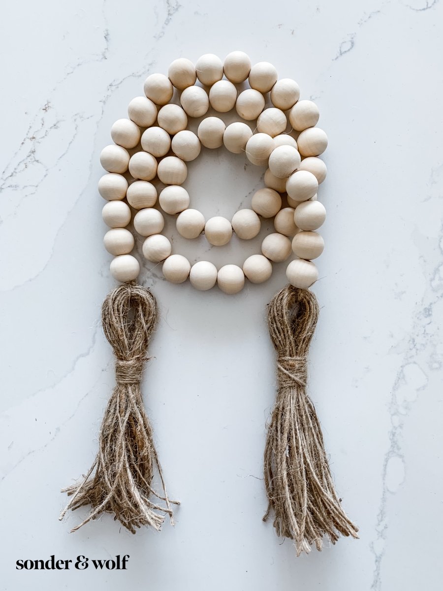 Handmade wood bead garland with jute tassels, perfect for home decor.