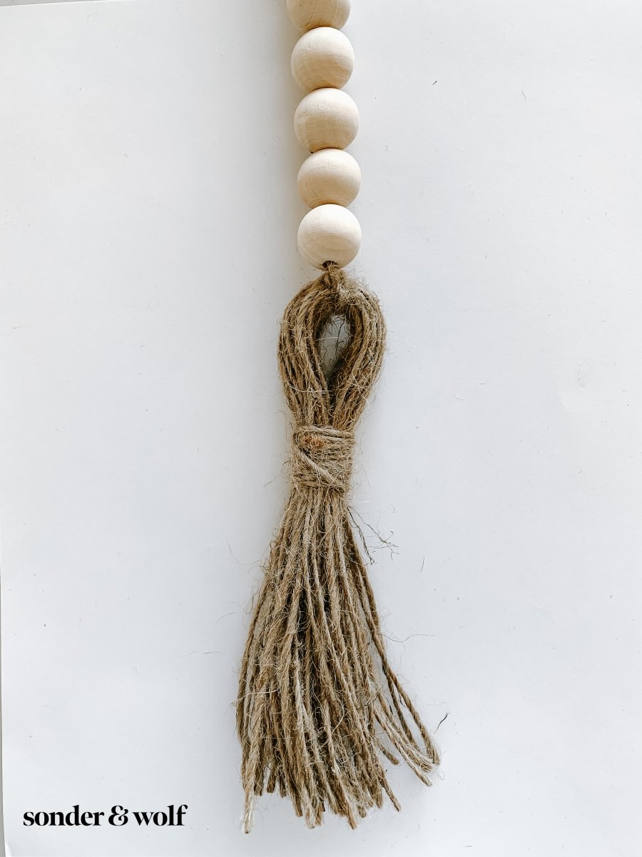 Handmade wood bead garland with jute tassels, perfect for home decor.