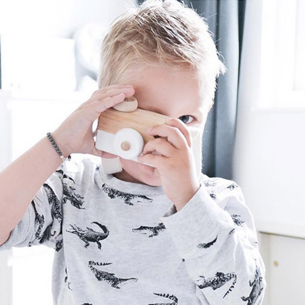 Child holding a wooden camera