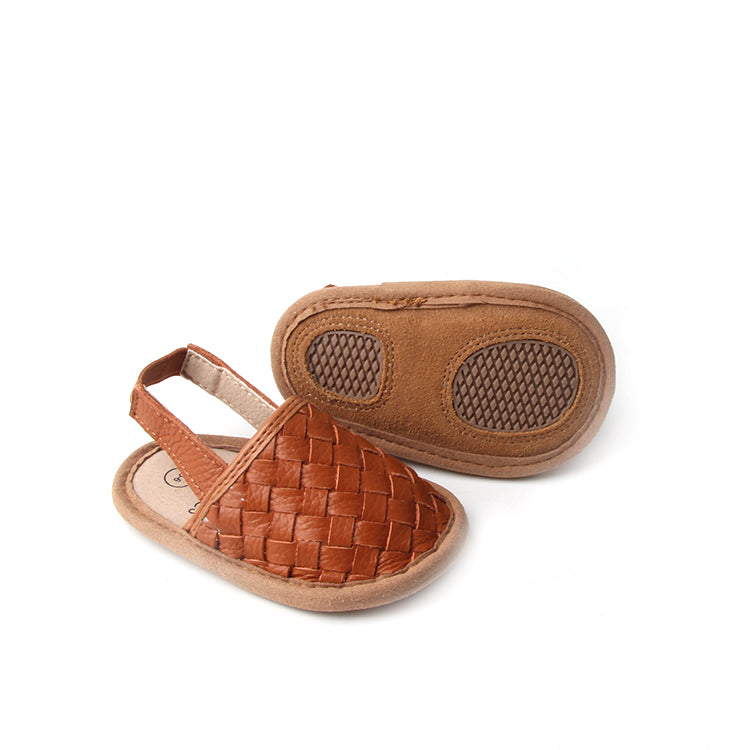 A pair of stylish woven leather sandals in Tawny and Latte colors, designed for toddlers with soft soles and ankle strap buckles.