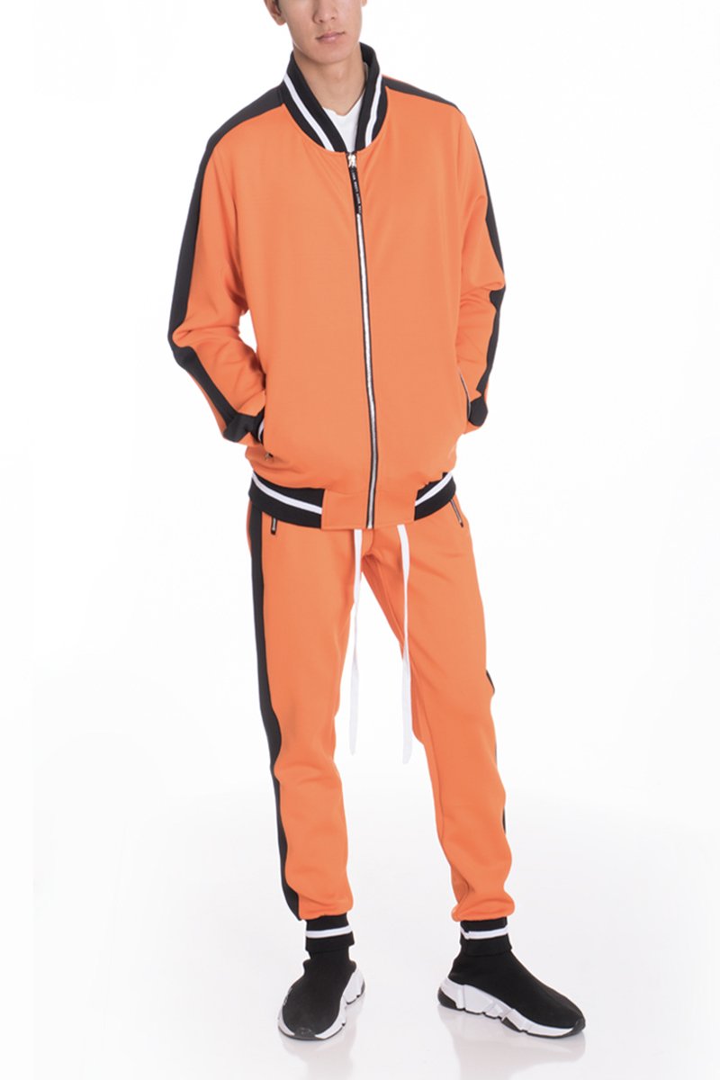 RALLY TRACK SET in vibrant orange featuring a tug-free zipper, ribbed elastic waist, and cuffs, perfect for casual wear and workouts.