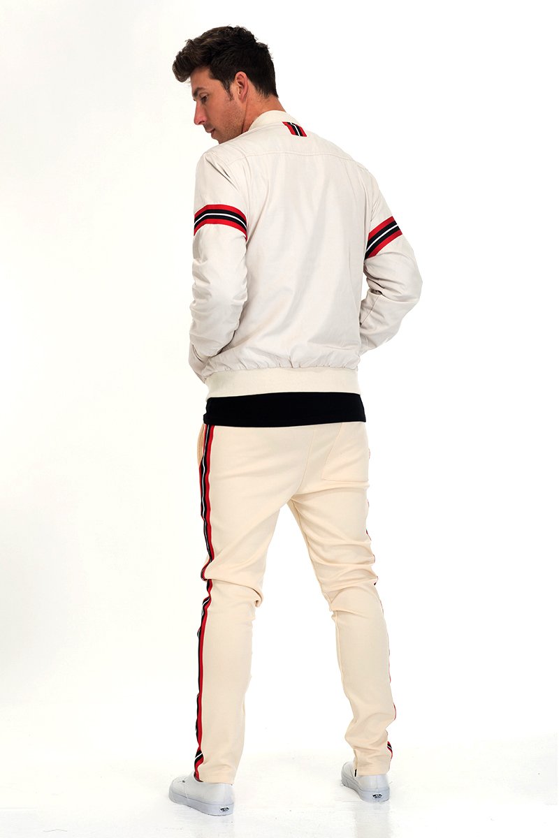 Beige SHIELD SET featuring a padded bomber jacket with tape detail, standard pockets, and hidden ankle zipper, displayed on a model.