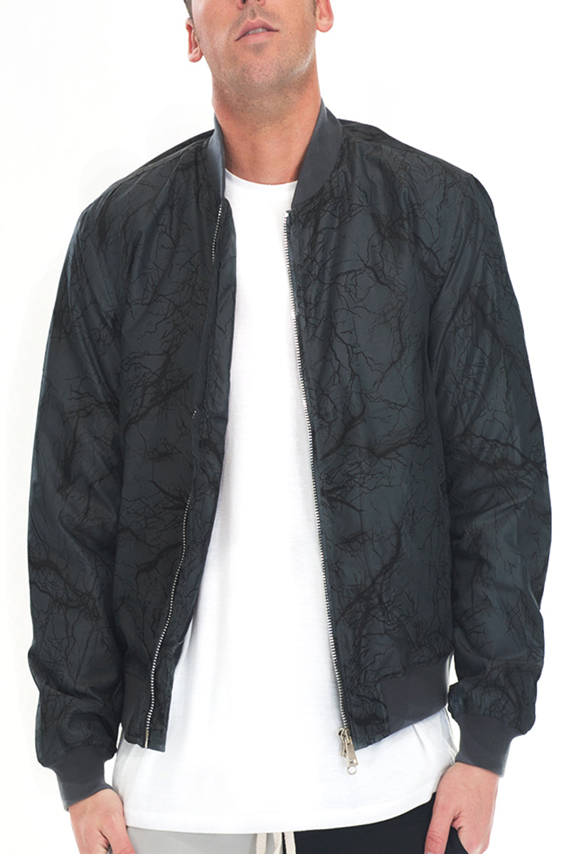 Man wearing black patterned bomber jacket.