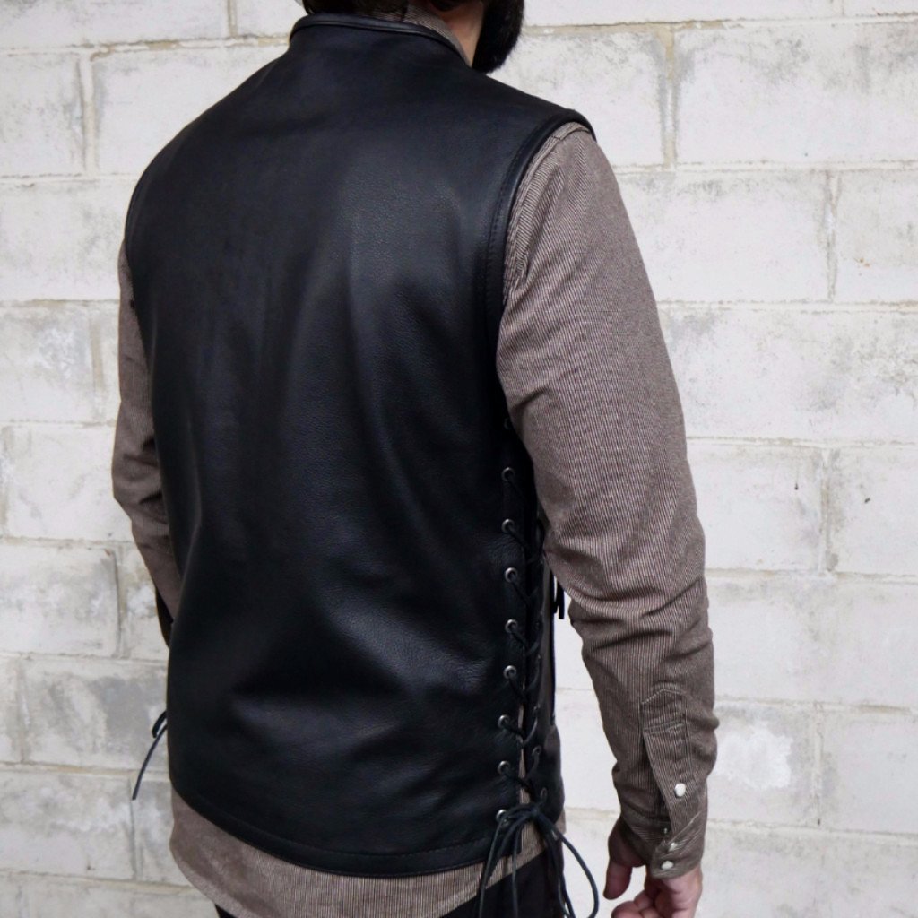 Brawler vest made of premium cowhide featuring a side lace design, zippered pockets, and concealed carry options.