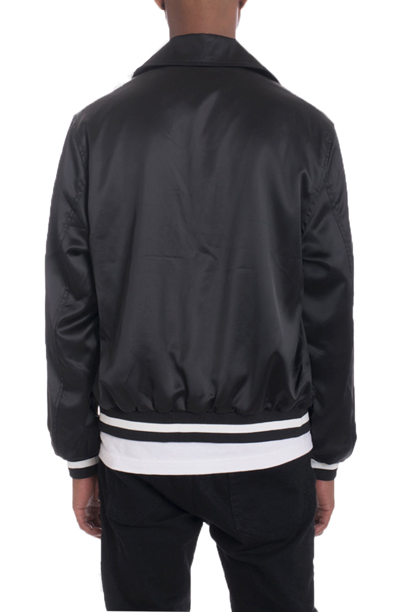 A stylish Luxe Satin Bomber jacket in a rich color, featuring a snap button closure and a single inner chest pocket, displayed on a mannequin.