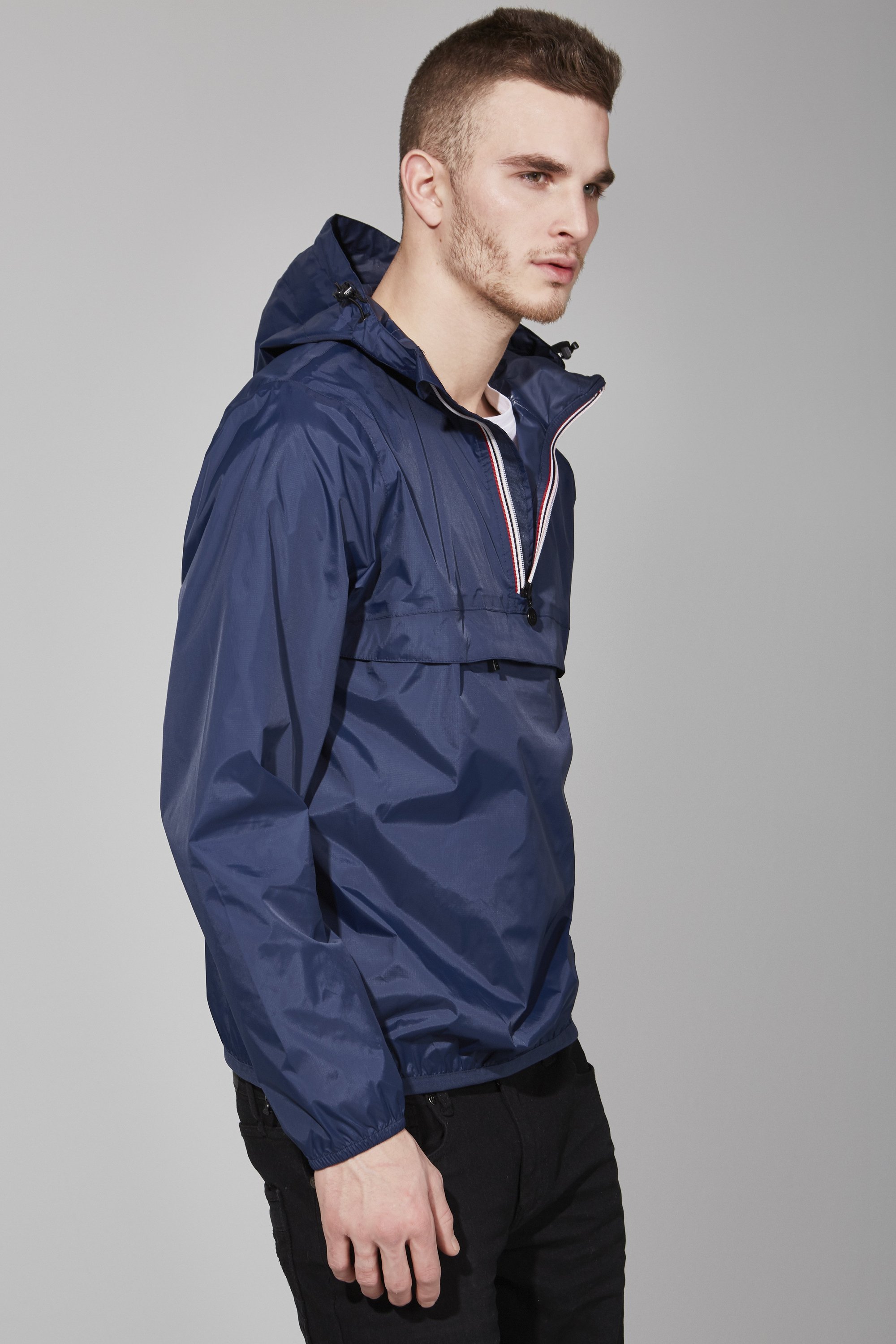 Men's navy quarter zip packable rain jacket, showcasing its sleek design and packable feature, ideal for outdoor activities.