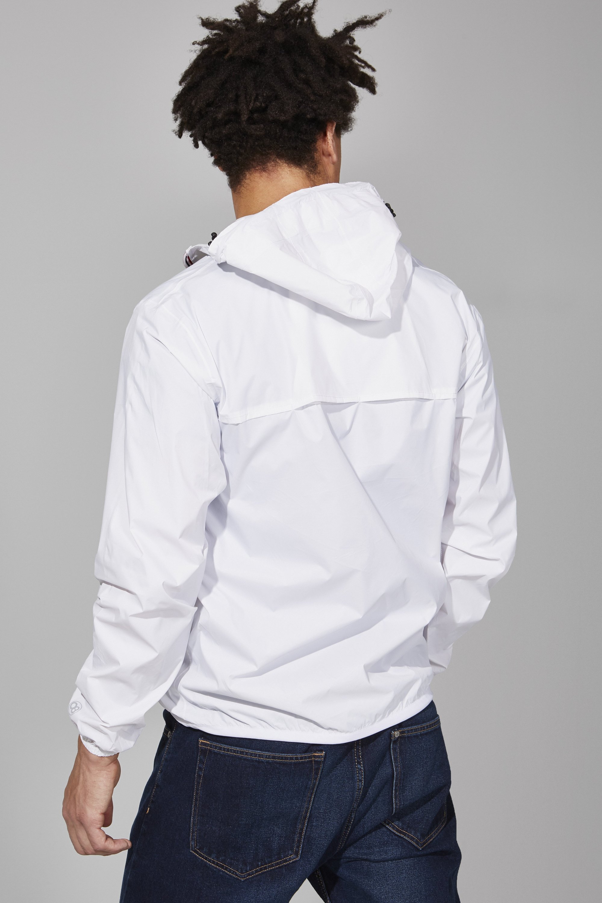 Men's white full zip packable rain jacket displayed on a mannequin, showcasing its sleek design and packable feature.