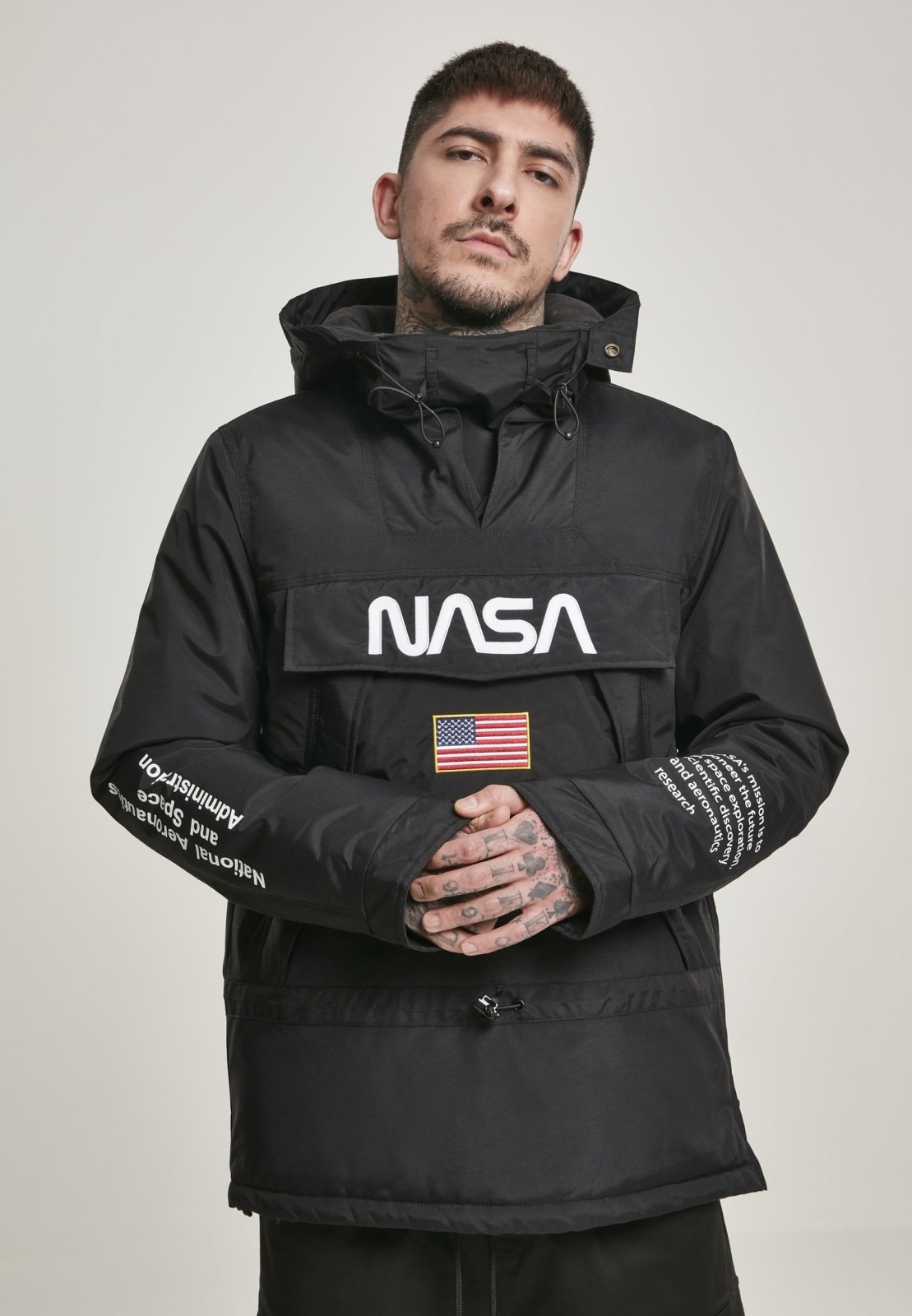 A stylish black windbreaker featuring NASA branding and a USA flag patch, designed with multiple pockets and a unique adjustable hood.