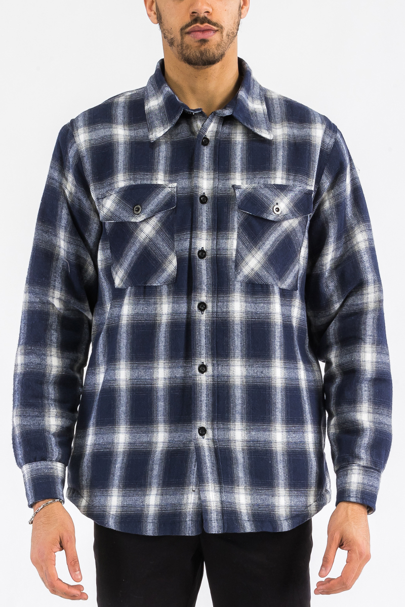 A stylish quilted flannel shirt featuring a button closure, cozy lining, and side pockets, perfect for layering and casual wear.